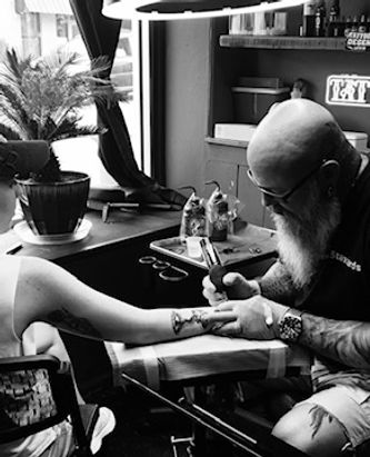 TJ Young tattooing a client inside the shop