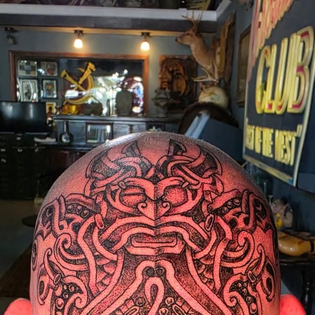 Norse-inspired black-and-gray head tattoo by TJ Young